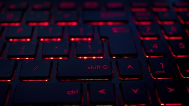 A close-up of a keyboard with red light glowing from under the keys