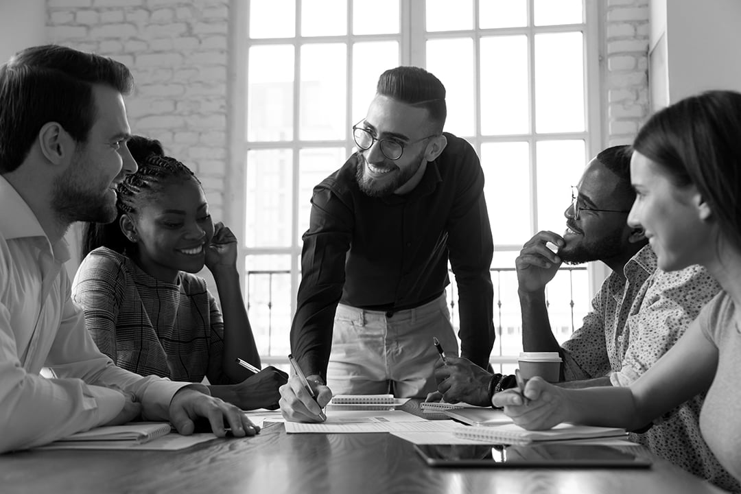 team members sitting at table collaborating 