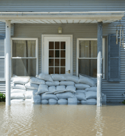 Home in flood with sandbags at door
